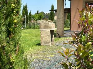 a stone bench in a yard next to a house at Fattoria Palazzeta - Pet & Family Friendly in Cecina