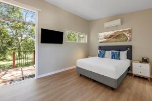 a bedroom with a bed and a balcony at Ramada Resort by Wyndham Phillip Island in Cowes +55 photos