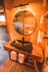uma casa de banho com um lavatório numa cabina de madeira em Casita boutique con tina exterior em Pichilemu