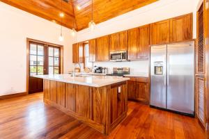 a kitchen with wooden cabinets and a stainless steel refrigerator at Closer to Heaven and The PoolClub at Mahogany Bay! in San Pedro
