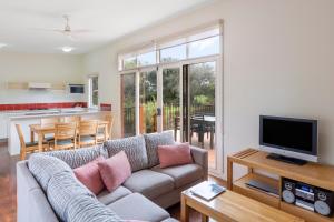 - un salon avec un canapé et une télévision dans l'établissement Ramada Resort by Wyndham Phillip Island, à Cowes