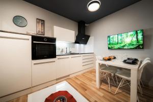 una cocina con armarios blancos y una mesa con sillas. en Cosy apartment, en Divača