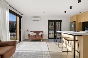 a kitchen and living room with a counter and a couch at Cardrona Creekside Apartment in Cardrona