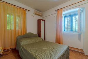 sypialnia z łóżkiem i oknem w obiekcie Apartments and rooms with WiFi Lastovo - 13678 w mieście Lastovo