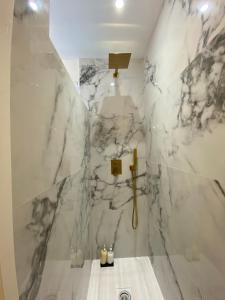 a bathroom with white marble walls and a shower at Apartamentos BEJAR - INDIGO in Béjar