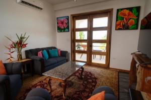 a living room with a couch and a table at Sandy Feet Beach Resort in Placencia