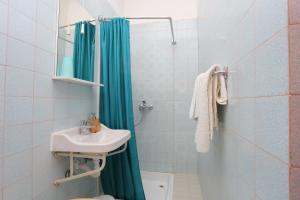 baño con lavabo y cortina de ducha azul en Apartments by the sea Brela, Makarska - 20598 en Brela