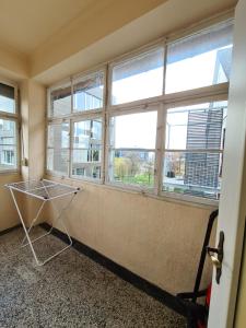 a room with three windows and a laundry basket in it at Wohnreich Ulm Zentral 3er WG in Ulm