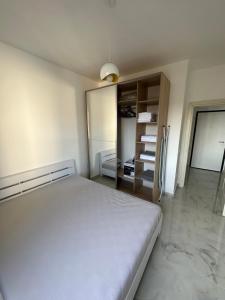 um quarto com uma cama branca e um closet em Beach front Durres 2 em Durrës