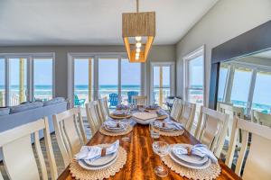 een eetkamer met een tafel en stoelen en de oceaan bij Seashore's Best in North Topsail Beach