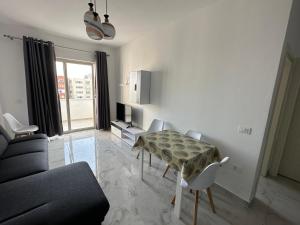 uma sala de estar com uma mesa e um sofá em Beach front Durres 2 em Durrës