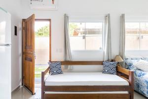 a small bedroom with a bed and a window at Suítes encantos das cigarras in São Sebastião