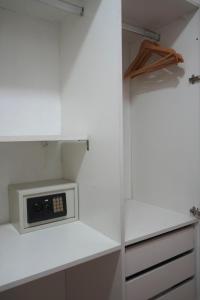 a white kitchen with a microwave on a shelf at Niceto Studio in Buenos Aires
