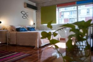 una camera da letto con un letto con cuscini blu e una finestra di Niceto Studio a Buenos Aires