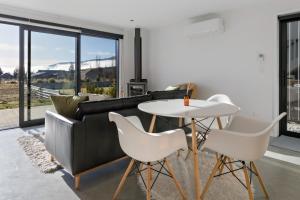 a living room with a couch and a table and chairs at Camp Cardrona Apartments in Cardrona
