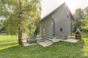 a building with a group of benches in a field at Holiday house with a parking space Fuzine, Gorski kotar - 20518 in Lokve