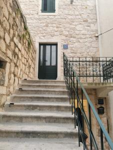 eine Treppe mit einer schwarzen Tür und einem Gebäude in der Unterkunft Apartments by the sea Makarska - 21443 in Makarska