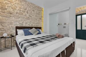 ein Schlafzimmer mit einem großen Bett und einer Steinmauer in der Unterkunft Apartments by the sea Makarska - 21443 in Makarska