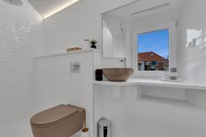 ein Bad mit einem WC, einem Waschbecken und einem Fenster in der Unterkunft Apartments by the sea Makarska - 21443 in Makarska