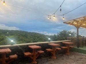 a row of stools sitting at a bar with a view at Cabinas Vista Al Golfo in Monteverde Costa Rica