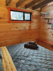 Dormitorio de una cabaña de madera con cama en M Refugios, Termas de Chillán en Pinto