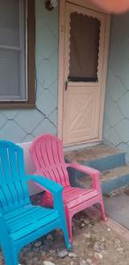 two colorful chairs sitting outside of a house at ARMANI MANOR Rustic UNIT 2 in Wildwood