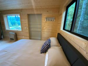a bedroom of a tiny house with a couch and windows at Oyster Lady Homer, AK in Homer