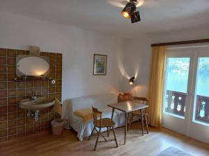 a living room with a table and a sink at Appartements direkt am See in Grundlsee