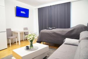 un salon avec un canapé et un lit dans l'établissement Railway station & Central studio, à Oulu