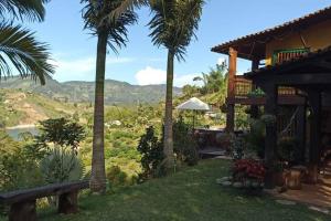 een huis met palmbomen en uitzicht op een vallei bij Cabaña El Refugio in El Peñol