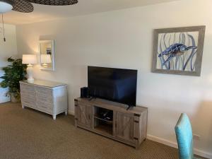 a living room with a flat screen tv on a wooden entertainment center at Maui Eldorado K211 in Kahana