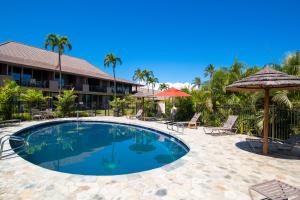 a pool at a resort with chairs and umbrellas at Maui Eldorado K211 in Kahana