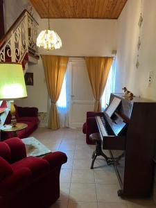 sala de estar con piano y sofá rojo en La casa de la Abuela en San Rafael