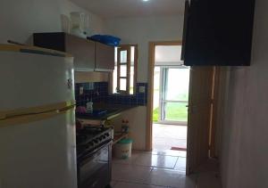 a kitchen with a refrigerator and an open door at Lugar perfeito para você e sua família in Rio Grande