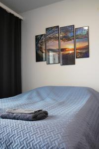 1 dormitorio con 1 cama con 4 cuadros en la pared en Top location IICenter IIParking en Oulu
