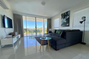 a living room with a couch and a table at Seachange Coolum Beach in Coolum Beach