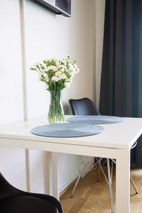 a white table with a vase of flowers on it at Top location IICenter IIParking in Oulu