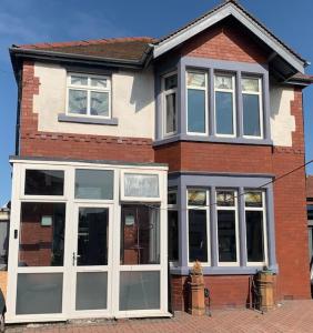 a brick house with large windows on a street at Family Holiday Home in Blackpool