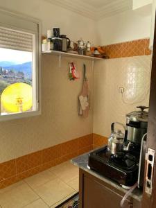 a kitchen with a stove and a window at APPARTEMENT AL WAHDA in Taza