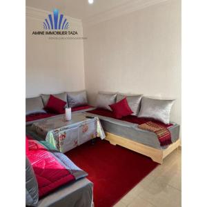 a living room with a couch and a red rug at APPARTEMENT AL WAHDA in Taza