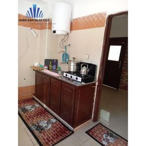 a kitchen with a stove and a counter top at APPARTEMENT AL WAHDA in Taza