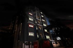 ein hohes Gebäude mit beleuchteten Fenstern in der Nacht in der Unterkunft Townhouse 1014 De Alphabet Hotel in Gachibowli