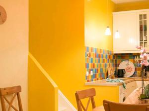 a kitchen with yellow walls and a table and chairs at Gîte Fresse-sur-Moselle, 3 pièces, 6 personnes - FR-1-589-43 in Fresse-sur-Moselle