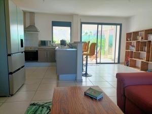 a kitchen and living room with a couch and a table at Beau T3 proche plage secteur Montabo à Cayenne in Cayenne
