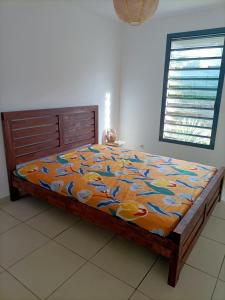 a bedroom with a bed with a colorful comforter at Beau T3 proche plage secteur Montabo à Cayenne in Cayenne