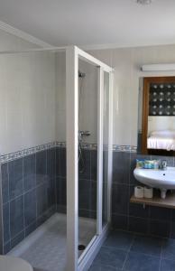 y baño con ducha y lavamanos. en Pension los Arcos, en Los Arcos