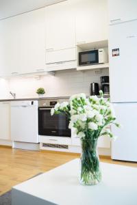 um vaso de flores sentado numa mesa numa cozinha em Top location IICenter IIParking em Oulu
