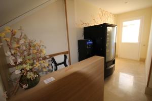 a room with a refrigerator and a table with a vase of flowers at Pension los Arcos in Los Arcos