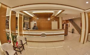 a man standing in a lobby with a hair salon at Gaziantep Garni Hotel in Gaziantep