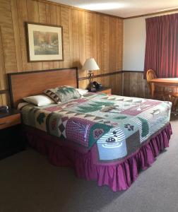 a bedroom with a large bed with a colorful blanket at Denali Park Hotel in Healy